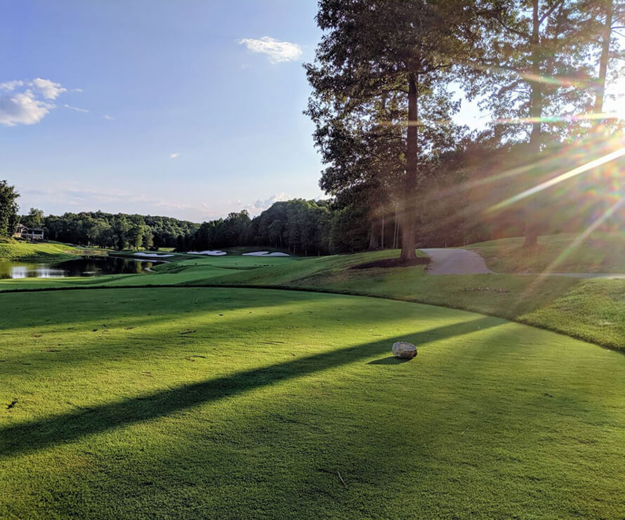 golf green and golf path near waterway